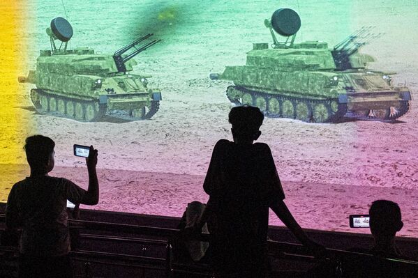 شبان يحضرون فيلمًا وثائقيًا قصيرًا يظهر مدافع ذاتية الدفع مضادة للطائرات في مقاطع أرشيفية من حرب 6 أكتوبر عام 1973 أثناء زيارتهم لمتحف "بانوراما حرب 6 أكتوبر" والنصب التذكاري في القاهرة، مصر - سبوتنيك عربي