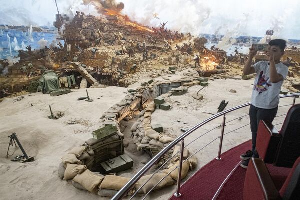 صبي يلتقط صورًا بالهاتف لمشهد حرب تم إعادة إنشائه أثناء زيارته لمتحف بانوراما حرب 6 أكتوبر والنصب التذكاري لحرب 6 أكتوبر عام 1973 في القاهرة، مصر - سبوتنيك عربي