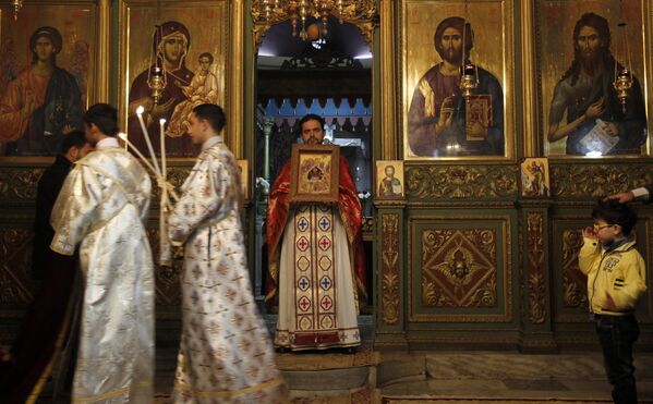 كاهن فلسطيني مسيحي أرثوذكسي يدير قداسا في كنيسة القديس برفيريوس خلال احتفالات عيد الميلاد في 7 يناير 2013 في مدينة غزة. وفقا للتقويم الغريغوري، يصادف عيد الميلاد الأرثوذكسي بعد 13 يوما من الاحتفال بالعيد الغربي في 25 ديسمبر بما يتماشى مع التقويم اليولياني. - سبوتنيك عربي