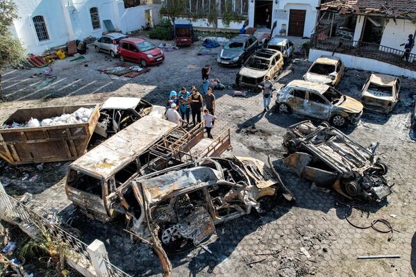 يُظهر هذا المشهد الجوي أشخاصًا يقفون أمام المباني المدمرة في موقع المستشفى "الأهلي العربي" (المعمداني) في وسط مدينة غزة، قطاع غزة، 18 أكتوبر 2023، في أعقاب غارة ليلية بالمكان. - سبوتنيك عربي