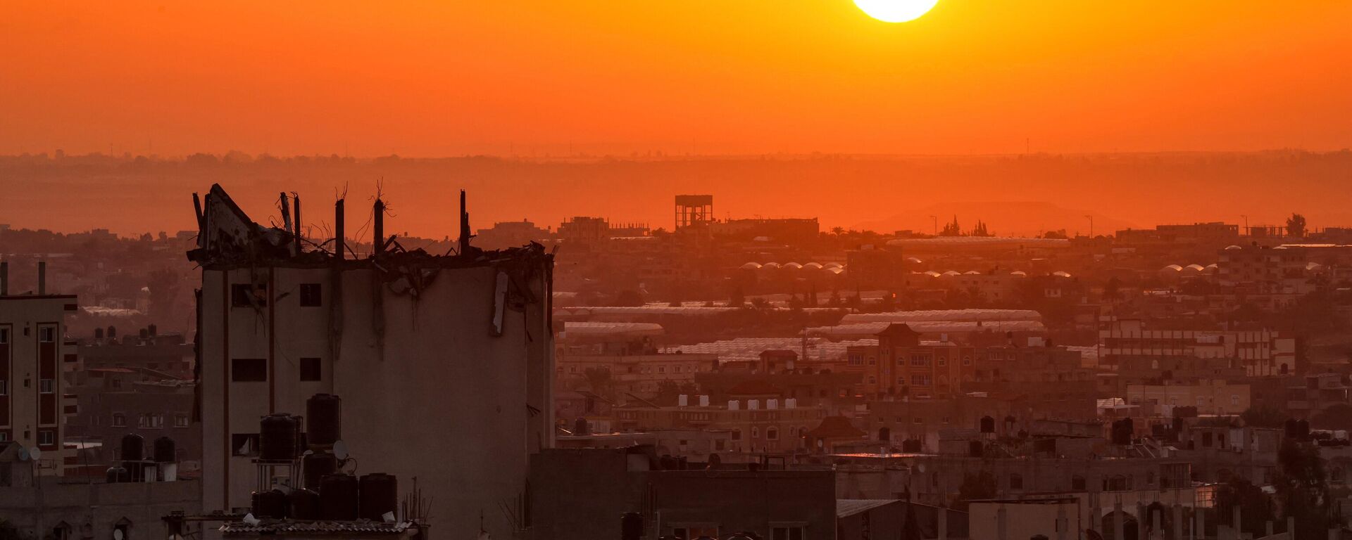 شروق الشمس على خلفية مبنى متضرر في أفق خان يونس في جنوب قطاع غزة، 19 أكتوبر 2023. - سبوتنيك عربي, 1920, 30.10.2023