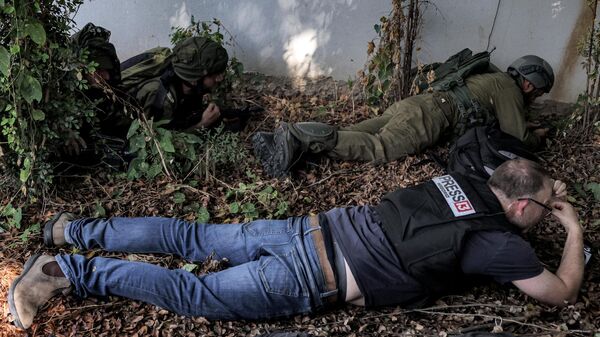 جنود وصحفيون من الجيش الإسرائيلي يحتمون أثناء إنذار بهجوم صاروخي على مدينة سديروت بجنوب إسرائيل بالقرب من الحدود مع غزة في 12 أكتوبر 2023. - سبوتنيك عربي