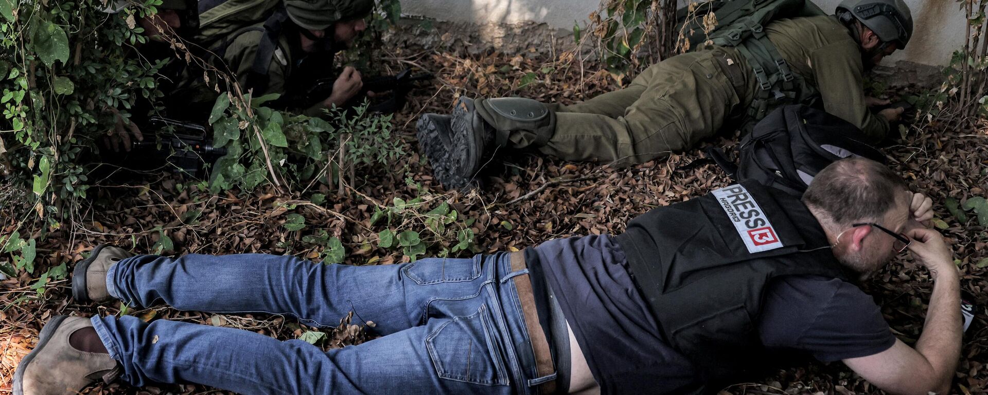 جنود وصحفيون من الجيش الإسرائيلي يحتمون أثناء إنذار بهجوم صاروخي على مدينة سديروت بجنوب إسرائيل بالقرب من الحدود مع غزة في 12 أكتوبر 2023. - سبوتنيك عربي, 1920, 02.01.2024