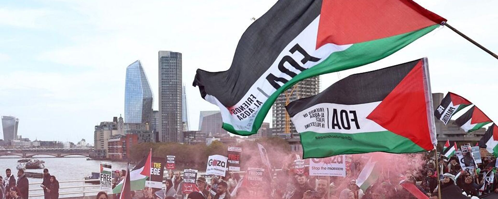 أشخاص يرفعون لافتات ويلوحون بالأعلام الفلسطينية أثناء عبورهم جسر واترلو خلال مسيرة من أجل فلسطين في لندن، 28 أكتوبر/ تشرين الأول 2023 - سبوتنيك عربي, 1920, 29.10.2023