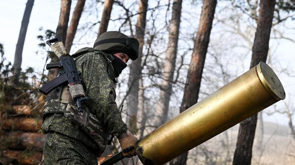 جندي من القوات المسلحة الروسية يحمل علبة خرطوشة من مدفع 2أ3بي غياتسينت-بي عيار 152 ملم في اتجاه محور كراسني ليمان، في منطقة العملية العسكرية الخاصة - سبوتنيك عربي