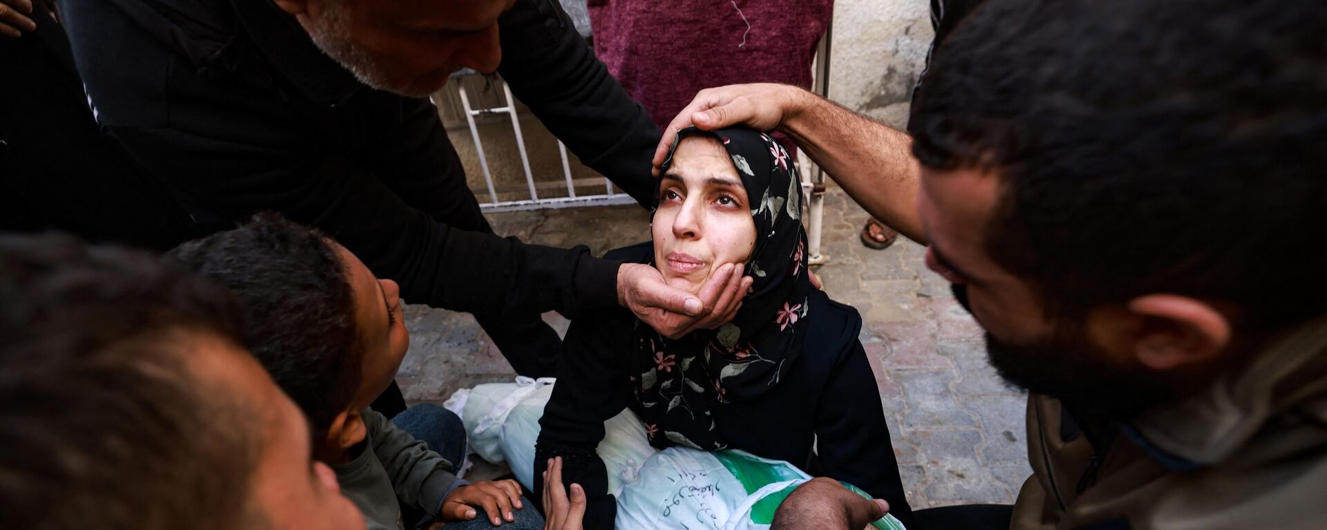 امرأة تحمل جثة طفلتها التي قُتلت في غارة إسرائيلية على رفح بجنوب قطاع غزة، في باحة مستشفى النجار في 1 ديسمبر 2023 - سبوتنيك عربي, 1920, 26.12.2023