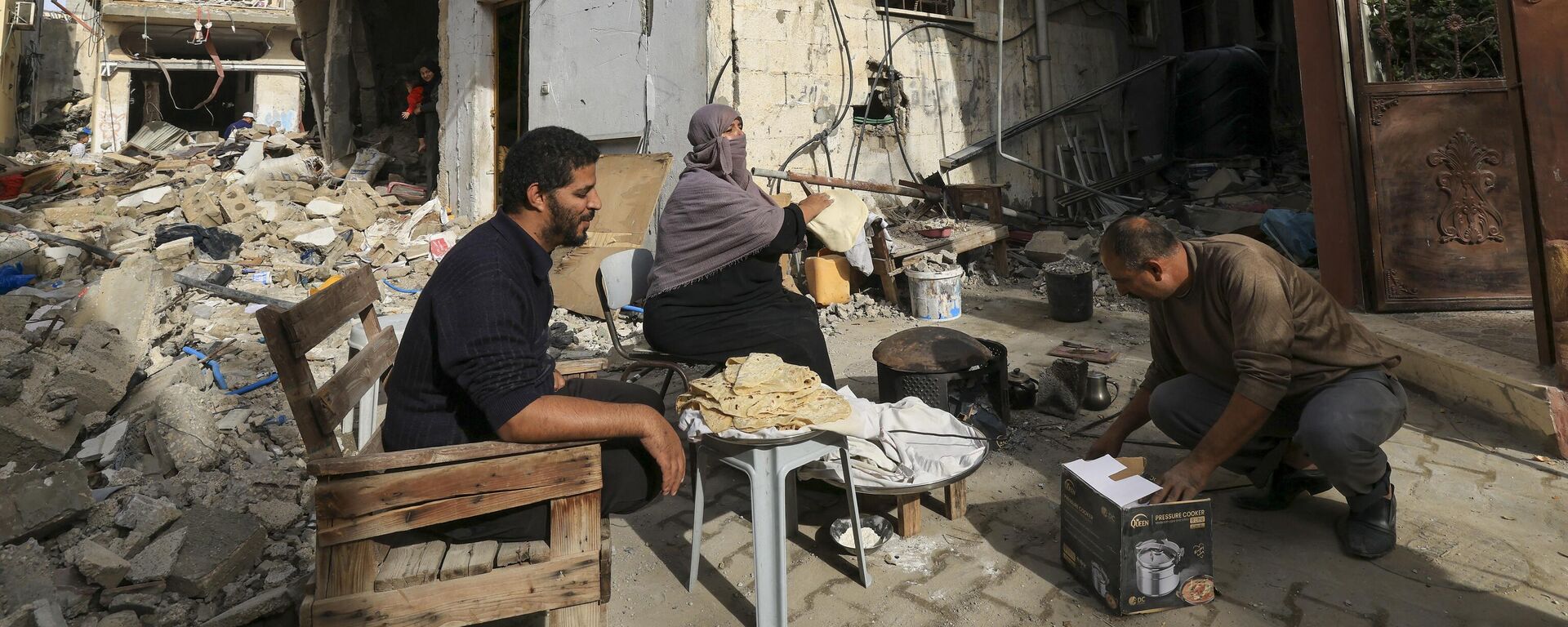 امرأة فلسطينية تخبز الخبز التقليدي خارج منزلها المتضرر في منطقة خزاعة على مشارف مدينة خان يونس جنوب قطاع غزة، بعد أسابيع من القصف الإسرائيلي، مع دخول الهدنة بين إسرائيل وحماس يومها الثاني في 25 نوفمبر 2023. - سبوتنيك عربي, 1920, 02.02.2024