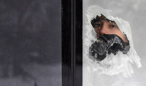 أحد ركاب حافلة عمومية ينظر من خلال نافذة تجمدت بفعل الصقيع عند درجة حرارة هواء تبلغ نحو27 درجة مئوية تحت الصفر في كراسنويارسك. خلال النهار، انخفضت درجة حرارة الهواء في كراسنويارسك إلى أقل من 30 درجة مئوية تحت الصفر، وفي المناطق الوسطى والجنوبية من المنطقة إلى أكثر من 40 درجة تحت الصفر. - سبوتنيك عربي