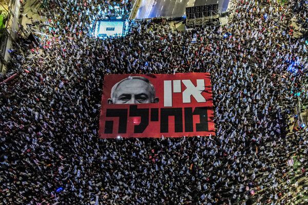 تُظهر هذه الصورة الجوية متظاهرين يرفعون لافتة عملاقة ضد رئيس الوزراء الإسرائيلي بنيامين نتنياهو خلال مسيرة ضد خطة الإصلاح القضائي للحكومة الإسرائيلية بالقرب من مول عزرائيلي في تل أبيب في 23 سبتمبر/ أيلول 2023. - سبوتنيك عربي