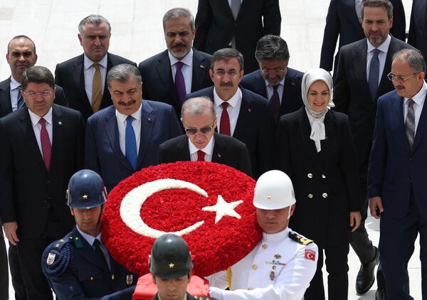 الرئيس التركي رجب طيب أردوغان وأعضاء حكومته الجديدة يسيرون مع جنود يحملون إكليلًا من الزهور أثناء زيارتهم لضريح مؤسس الجمهورية التركية مصطفى كمال أتاتورك، قبل أول اجتماع لمجلس الوزراء في أنقرة، في 6 يونيو 2023. كشف الرئيس التركي النقاب عن تشكيلة حكومته الجديدة في 3 يونيو بعد فوزه في جولة الإعادة التاريخية ليتولى ولاية ثالثة في منصبه. - سبوتنيك عربي
