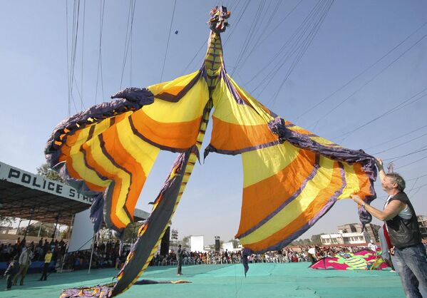 متسابق ألماني يعرض طائرته الورقية على شكل تنين بطول 16 مترا (52 قدما) أمام الجمهور خلال مهرجان الطائرات الورقية الدولي في أحمد آباد، الهند، السبت، 12 يناير، 2008. - سبوتنيك عربي