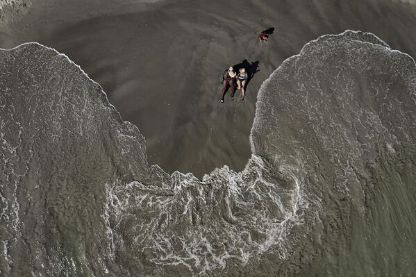 نساء يأخذن حمامًا شمسيًا على شاطئ "إل-ياك" في جزيرة مارغريتا، فنزويلا، 13 يناير 2024. - سبوتنيك عربي