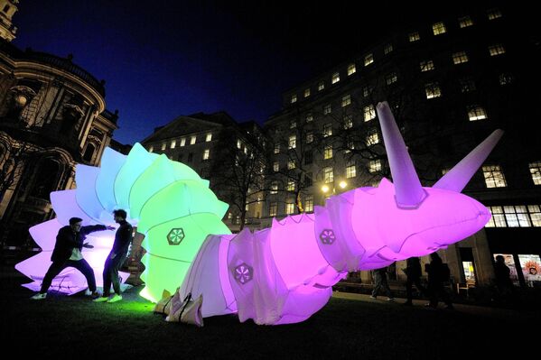 يتفاعل الناس مع روبوت عملاق قابل للنفخ، حيث تم الكشف عن روبوتات على طول الطريق العام "ذا ستراند"  بواسطة "آير جيانتز" مع كلية كينغز لندن، في لندن، 16 يناير 2024. حديقة "ذا غلوبوت"عبارة عن تركيب للروبوتات الناعمة العملاقة المعروضة على طول "ذا ستراند" في شارع "آلدویج"، في 16 يناير 2024. تستجيب الروبوتات القابلة للنفخ للتفاعل البشري وللضوء والصوت، وهي أطول كثيرًا من الحافلات ذات الطابقين. - سبوتنيك عربي