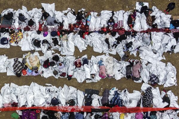 يُظهر هذا المنظر الجوي المهاجرين الذين ينتظرون المعالجة في مركز عبور لدوريات الحدود الأمريكية بعد أن عبروا الحدود من المكسيك في إيغل باس، تكساس، في 22 ديسمبر/ كانون الأول 2023. وقع الحاكم الجمهوري لتكساس على مشروع قانون في 18 ديسمبر 2023، من شأنه السماح لشرطة الولاية باعتقال وترحيل المهاجرين الذين يعبرون الحدود بشكل غير قانوني إلى الولايات المتحدة من المكسيك. - سبوتنيك عربي