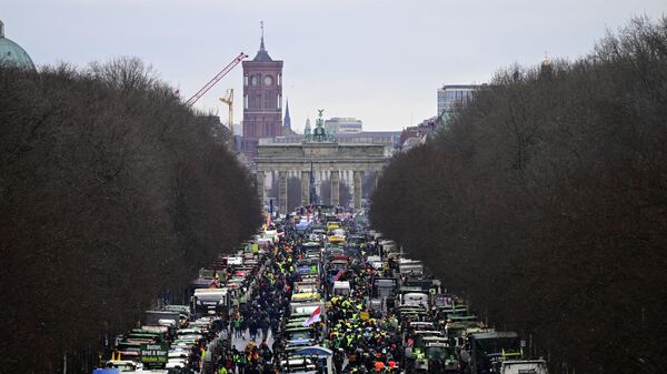 تقف الجرارات والشاحنات أمام بوابة براندنبورغ الشهيرة في برلين، كما يمكن رؤية قاعة المدينة الحمراء بالعاصمة الألمانية في الخلفية خلال احتجاج المزارعين وسائقي الشاحنات، في 15 يناير 2024 في برلين - سبوتنيك عربي