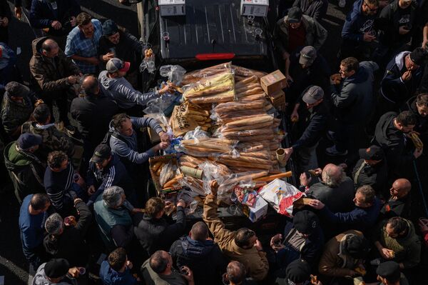 مصنّعو النبيذ المحتجون من ناربون (فرنسا) والمناطق المحيطة بها، يتمكنون من الحصول على أرغفة خبز أثناء سيطرتهم على الطريق السريع A9 خلال احتجاج على الضرائب وانخفاض الدخل. - سبوتنيك عربي