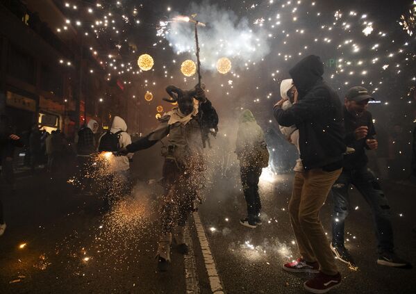 أحد المشاركين يرتدي زي شيطان يلوح بعصا بها ألعاب نارية خلال مهرجان Correfoc التقليدي (تشغيل النار) في بالما دي مايوركا. - سبوتنيك عربي