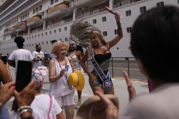 سائحة ترقص السامبا جنبًا إلى جنب مع فنانة تحيّي الناس أثناء إنزال سفينة سياحية في ميناء ريو دي جانيرو، البرازيل. - سبوتنيك عربي