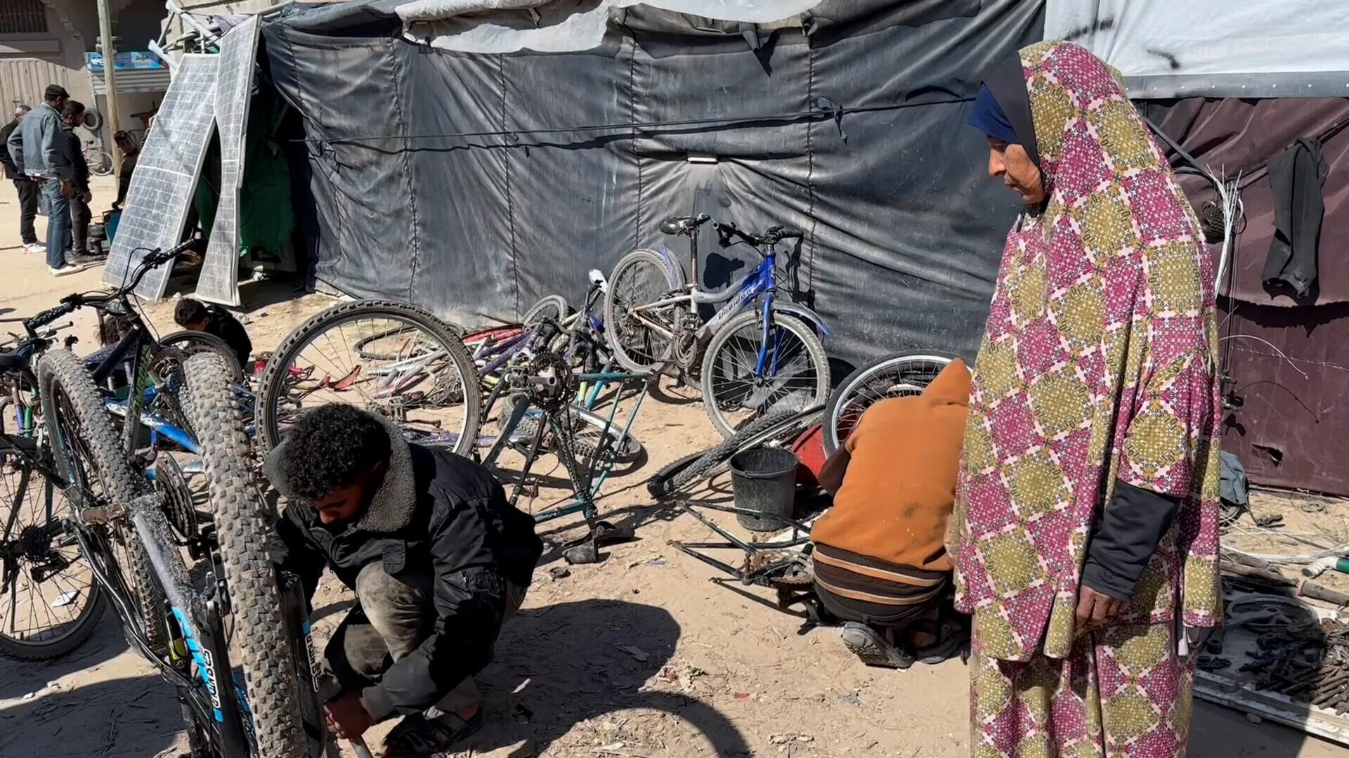 عائلة نازحة تحول خيمتها إلى مكان لتصليح الدرجات الهوائية في دير البلح وسط قطاع غزة - سبوتنيك عربي, 1920, 26.02.2024