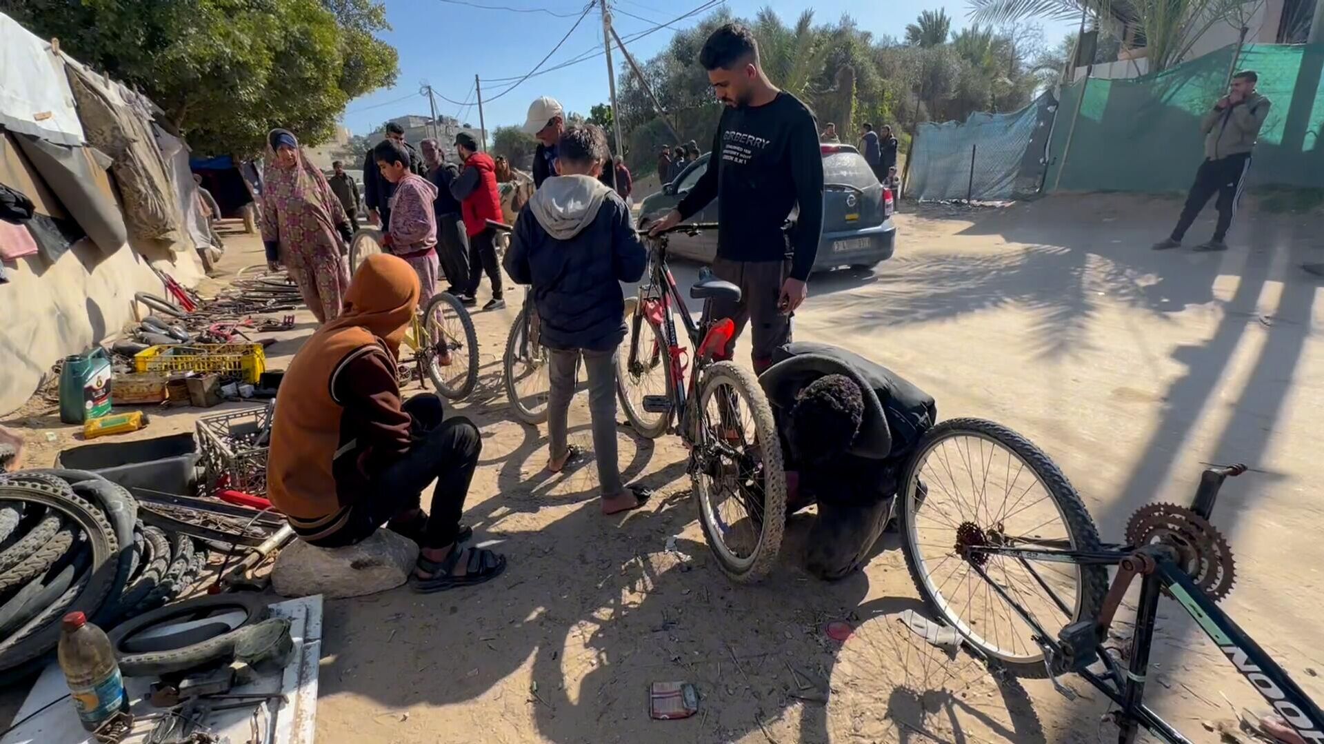 عائلة نازحة تحول خيمتها إلى مكان لتصليح الدرجات الهوائية في دير البلح وسط قطاع غزة - سبوتنيك عربي, 1920, 26.02.2024