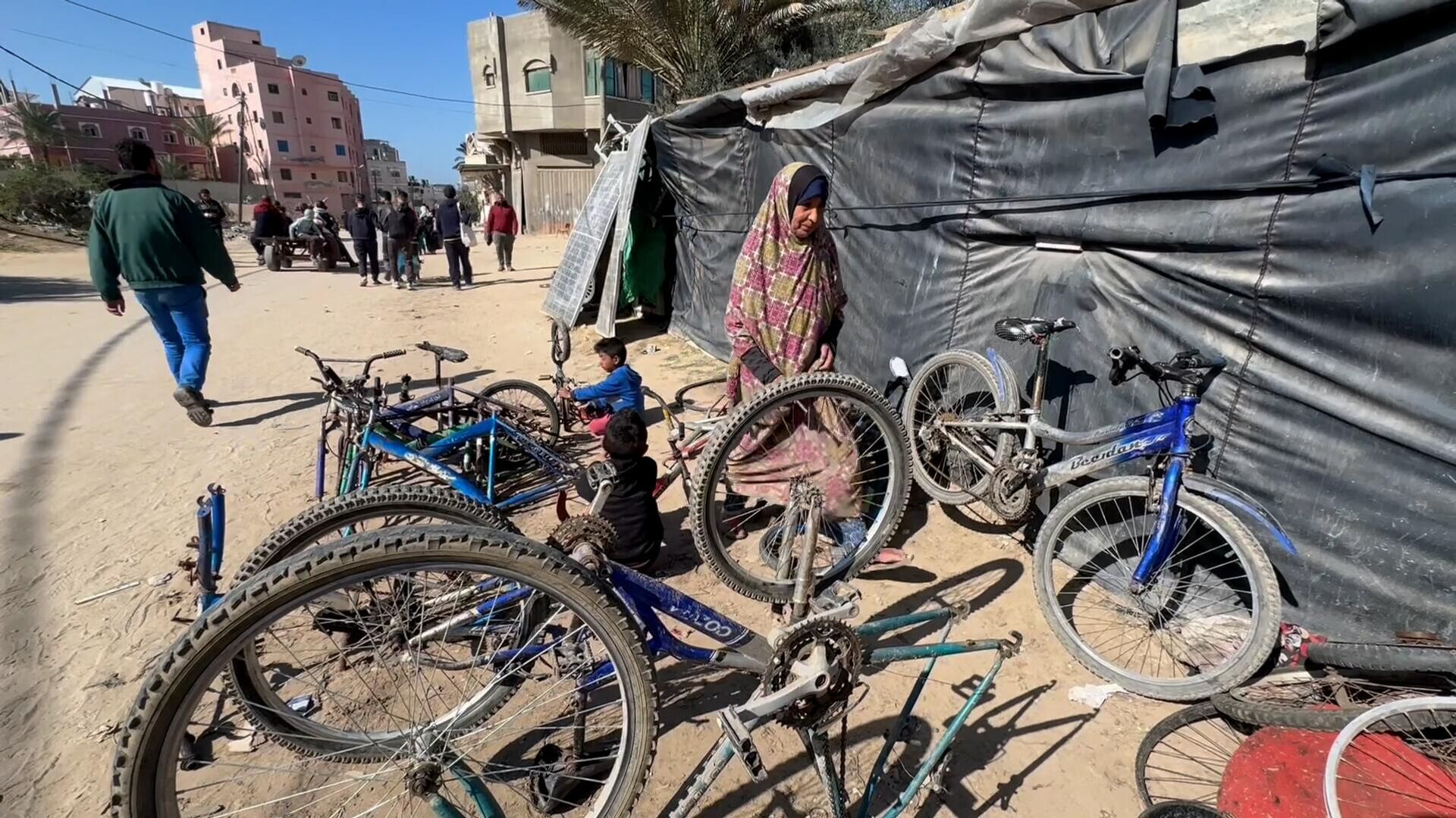 عائلة نازحة تحول خيمتها إلى مكان لتصليح الدرجات الهوائية في دير البلح وسط قطاع غزة - سبوتنيك عربي, 1920, 26.02.2024