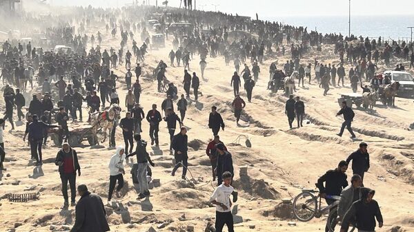 فلسطينيون ينتظرون المساعدات الإنسانية على شاطئ البحر في مدينة غزة، قطاع غزة، 25 فبراير 2024. - سبوتنيك عربي