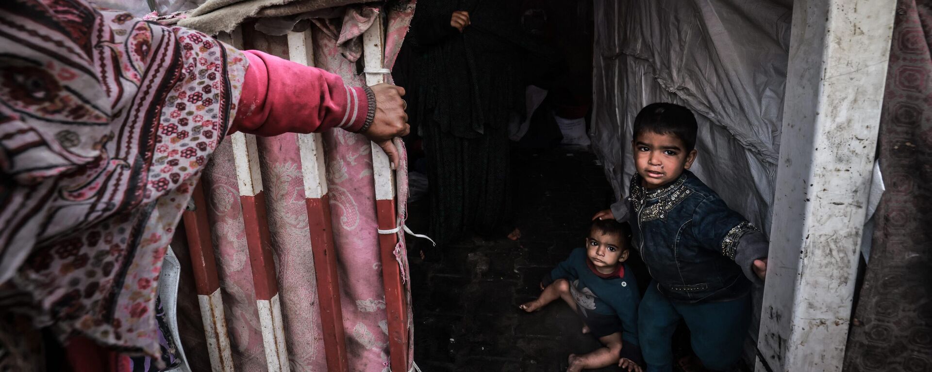 أطفال غزة - أطفال فلسطينيون نازحون ينتظرون داخل خيامهم المؤقتة في مخيم بجانب أحد شوارع رفح، قطاع غزة، فلسطين 14 مارس 2024
 - سبوتنيك عربي, 1920, 17.03.2024
