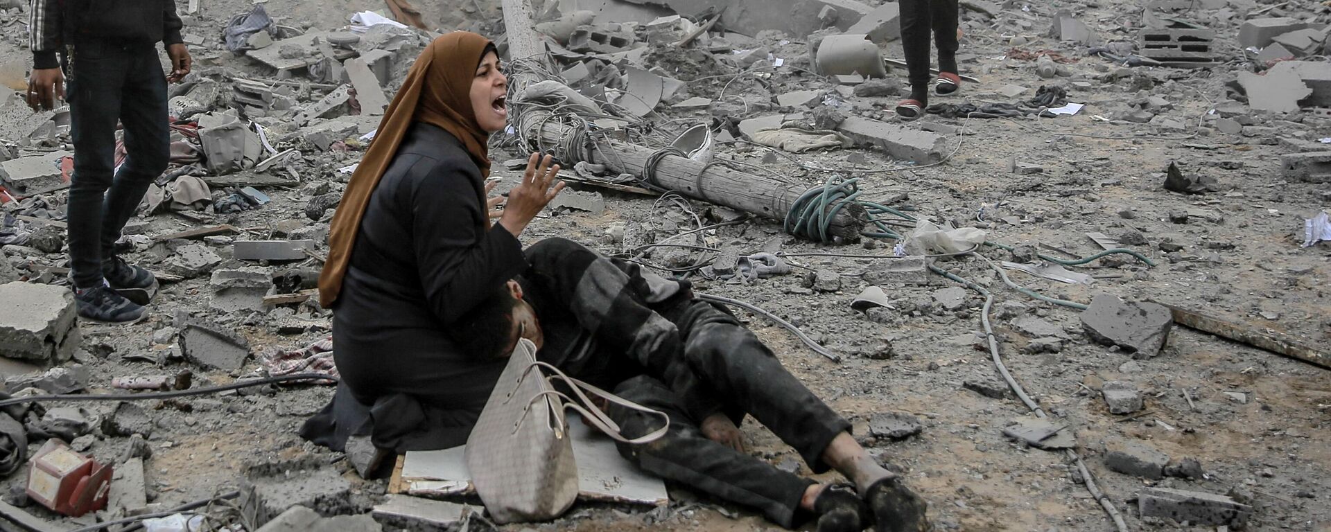 رد فعل امرأة فلسطينية وهي تحتضن طفلاً جريحًا بعد القصف الإسرائيلي على وسط مدينة غزة، فلسطين في 18 مارس 2024 - سبوتنيك عربي, 1920, 20.03.2024