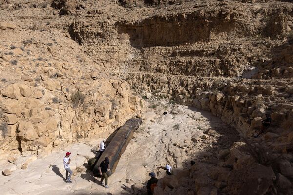 أفراد عسكريون إسرائيليون يرتدون ملابس مدنية يفحصون جزءًا من صاروخ بالستي إيراني، تم العثور عليه، في الآونة الأخيرة، في منطقة مفتوحة بالقرب من مدينة عراد الجنوبية، في 24 أبريل 2024. نفذت إيران هجومًا مباشرًا غير مسبوق على إسرائيل يوم 14 أبريل الجاري، باستخدام أكثر من 300 طائرة مسيرة وصواريخ &quot;كروز&quot; وصواريخ بالستية، ردا على الغارة الجوية، التي وقعت في الأول من أبريل الجاري، على القنصلية الإيرانية في دمشق، وتم اعتراض جميع المسيرات والصواريخ تقريبًا، وفقًا للجيش الإسرائيلي. - سبوتنيك عربي