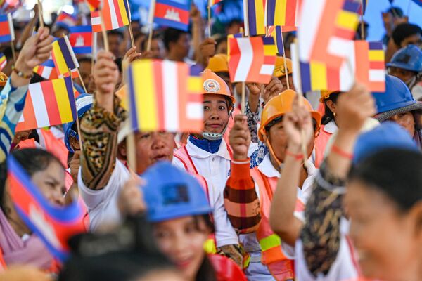 عمال يحملون الأعلام وهم يسيرون في أحد الشوارع خلال الاحتفال بيوم العمال العالمي في كومبوديا في 1 مايو 2024. - سبوتنيك عربي