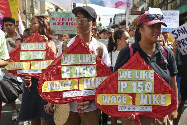 عمال فلبينيون يحملون لافتات وملصقات خلال احتجاج بمناسبة يوم العمال العالمي بالقرب من القصر الرئاسي في مانيلا الفلبينية. - سبوتنيك عربي