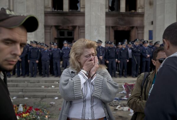 امرأة تبكي بعد أن أمسكتها قوات الشرطة التي تحرس المبنى النقابي المحترق في أوديسا، أوكرانيا، السبت 3 مايو 2014. - سبوتنيك عربي