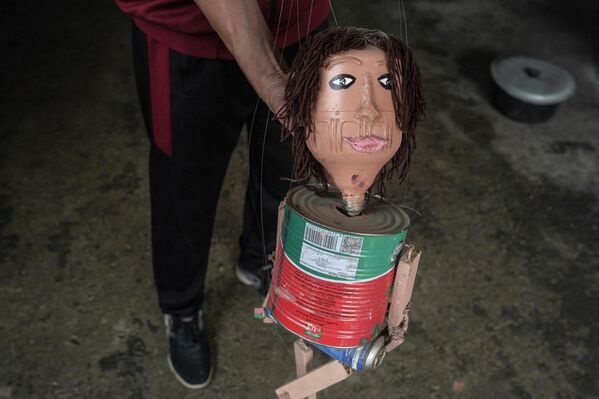 الفلسطيني مهدي كريرة يعرض إحدى دمياته، المصنوعة من علب الصفيح، في ورشته في دير البلح، وسط قطاع غزة، في 27 أبريل 2024 - سبوتنيك عربي