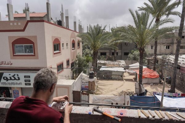الفلسطيني مهدي كريرة يعمل على دمية مصنوعة من علب المعلبات في ورشته في دير البلح وسط قطاع غزة، 27 أبريل 2024 - سبوتنيك عربي