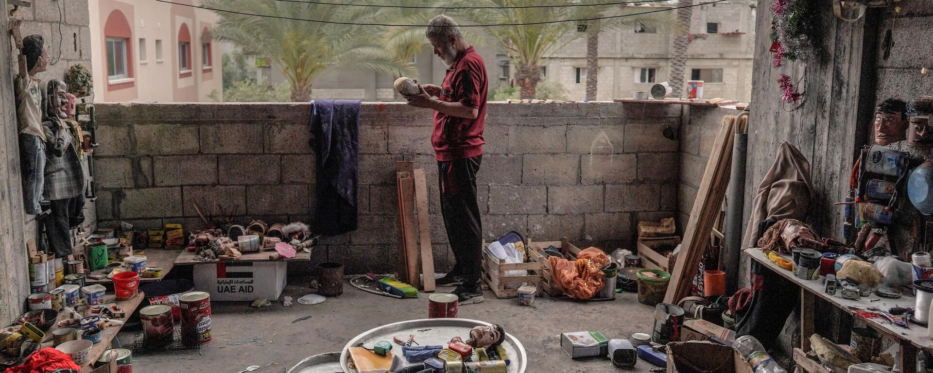 الفلسطيني مهدي كريرة يعمل على دمية مصنوعة من علب لمعلبات القديمة في ورشته في دير البلح وسط قطاع غزة، في 27 أبريل 2024 - سبوتنيك عربي, 1920, 03.05.2024