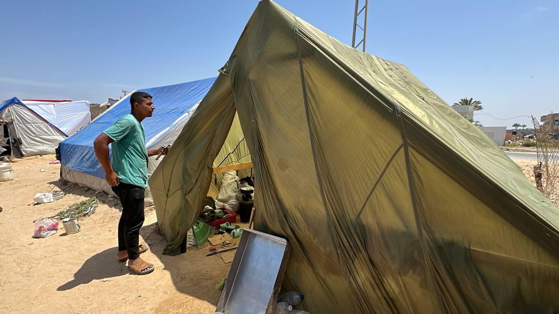 فلسطيني يشيد خيمة لعائلته من مظلات الإنزال الجوي في قطاع غزة - سبوتنيك عربي, 1920, 06.05.2024