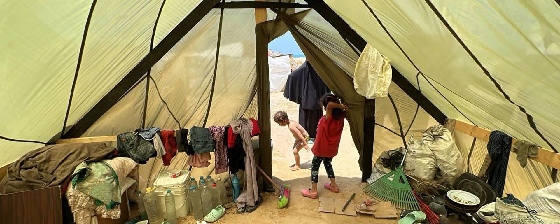 فلسطيني يشيد خيمة لعائلته من مظلات الإنزال الجوي في قطاع غزة - سبوتنيك عربي, 1920, 11.05.2024