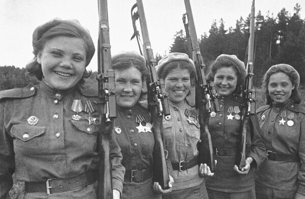 مجموعة من القناصات السوفييتيات يتدربن قبل وقت قصير من إرسالهن إلى الجبهة القتالية. من اليسار إلى اليمين: حاملات وسام المجد، القناصة نينا لوبكوفسكايا، وليوبا ماكاروفا، وشورا فينوغرادوفا، ويوليا بيلوسوفا، وآنيا نوسوفا. صورة من جبهة البلطيق الثانية، 13 سبتمبر 1944 - سبوتنيك عربي