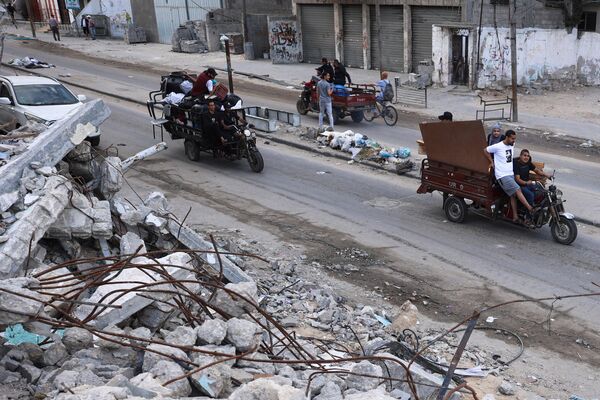 فلسطينيون ينقلون أمتعتهم أثناء نزوحهم من رفح جنوبي قطاع غزة نحو منطقة أكثر أمانًا في 12 مايو 2024 - سبوتنيك عربي