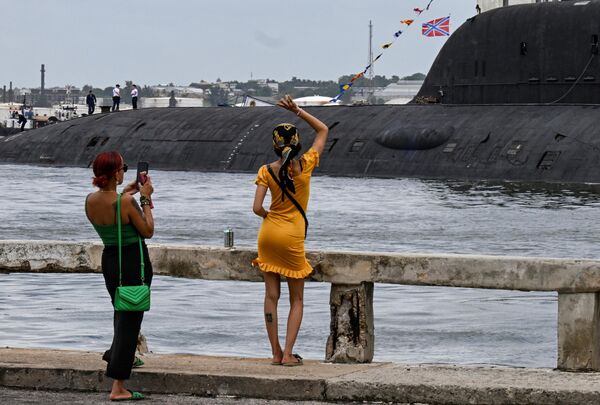 امرأة تلوح لأفراد طاقم الغواصة &quot;قازان&quot; التي تعمل بالطاقة النووية، وهي جزء من مفرزة البحرية الروسية التي تزور كوبا، بعد وصولها إلى ميناء هافانا في 12 يونيو/حزيران 2024 - سبوتنيك عربي
