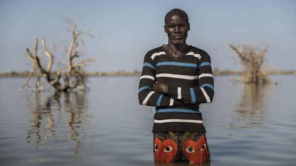 القائمة المختصرة لوك دراي / المملكة المتحدة المناخ الحقيقي لجنوب السودان، مسلسل جون ماليش، البالغ من العمر أربعين عامًا، يقف لالتقاط صورة حيث كان منزله يقف ذات يوم في 29 نوفمبر 2023 في تونغ، جنوب السودان. - سبوتنيك عربي