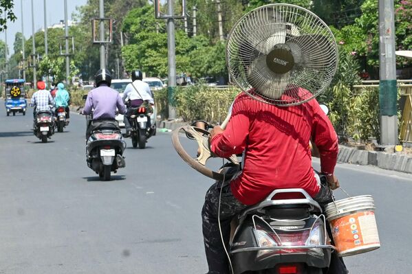 راكب في الهند يحمل مروحة على دراجة في يوم صيفي حار في أمريتسار في 18 يونيو 2024. - سبوتنيك عربي