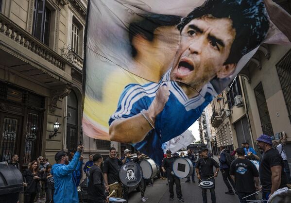 يتجمع المشجعون للاحتفال بالذكرى السنوية لـ هدف القرن الذي سجله أسطورة كرة القدم دييغو مارادونا ضد إنجلترا خلال ربع نهائي كأس العالم 1986 في بوينس آيرس، الأرجنتين. - سبوتنيك عربي
