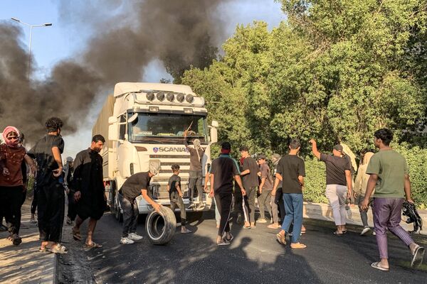 متظاهرون يتجمعون لإغلاق طريق خلال احتجاج على انقطاع التيار الكهربائي ونقص المياه، وسط ارتفاع درجات الحرارة في البلاد، في قرية الشافعية على المشارف الجنوبية الغربية للديوانية، جنوب وسط العراق، في 15 يوليو 2024. - سبوتنيك عربي