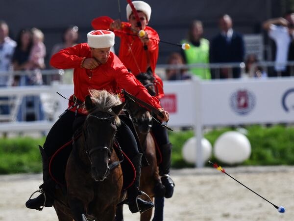 الفارسان الروسيان يان ليتوفالتسيف، وسافيلي بورودينكو، يرميان السهام خلال مشاركتهما في مسابقة "الفروسية والرماية" الدولية، في مجمع "في دي إن خا"، في موسكو. - سبوتنيك عربي