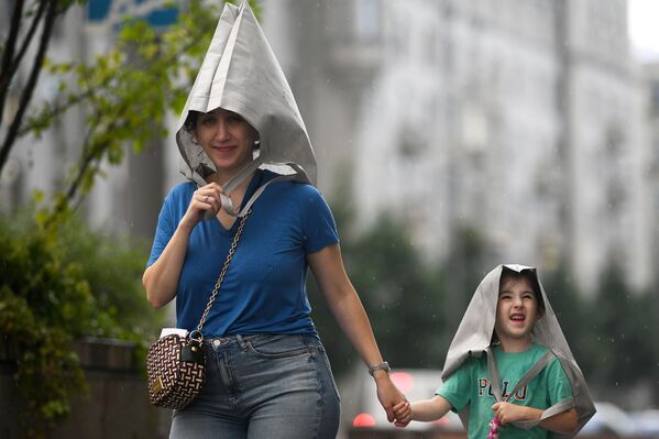 صورة لأشخاص تحت المطر في موسكو، روسيا. - سبوتنيك عربي