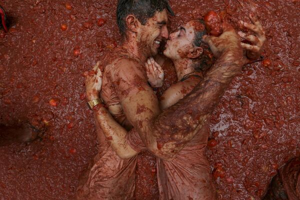 يستلقي المشاركون في بركة من الطماطم المهروسة خلال مهرجان الطماطم السنوي &quot;Tomatina&quot;، في قرية بونول بالقرب من فالنسي، إسبانيا، 28 أغسطس 2024. - سبوتنيك عربي