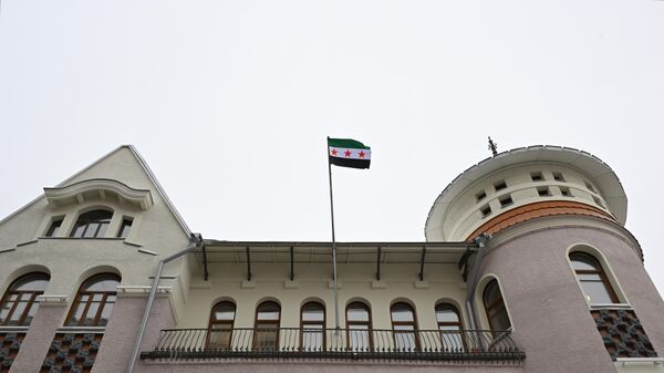 رفع العاملون في مبنى السفارة السورية في موسكو العلم السوري الجديد الذي اعتمدته سابقاً فصائل من المعارضة السورية المسلحة. - سبوتنيك عربي