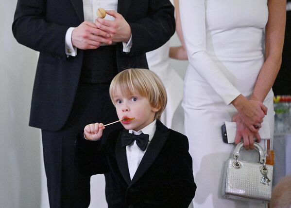 طفل صغير يتناول الحلوى أمام شجرة عيد الميلاد الخيرية "تسيساريفيتش" في بيت باشكوف في موسكو، روسيا. - سبوتنيك عربي