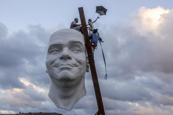 عمال يقومون بتركيب قطعة من أعمال الفنان، عثماني بيتانكورت، كجزء من معرض "بينالي هافانا" الخامس عشر، في هافانا، كوبا. - سبوتنيك عربي